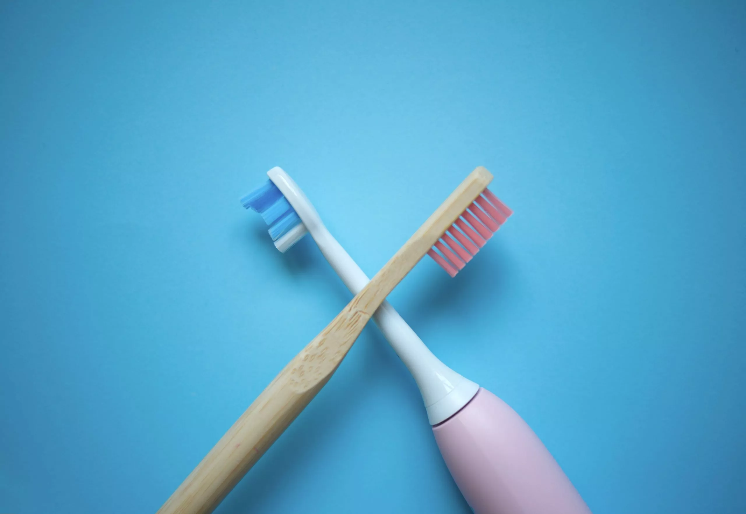 two ultrasonic electric toothbrushes on a blue background