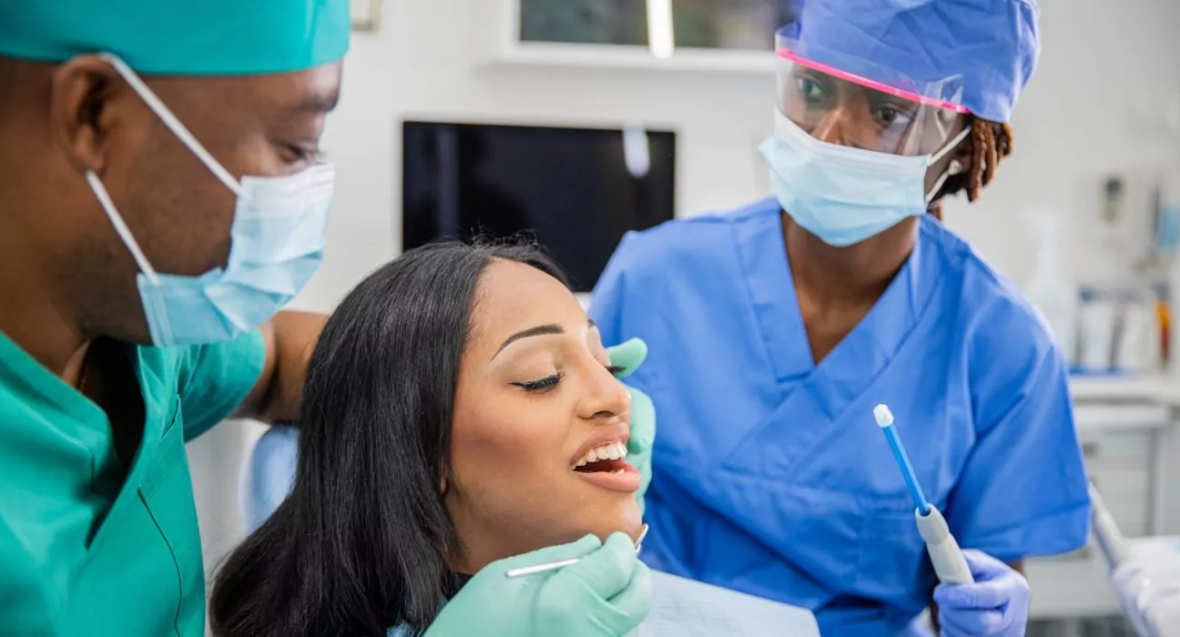 Girl with open mouth during a dental visit, dentist and assistant at work, dental health concept
