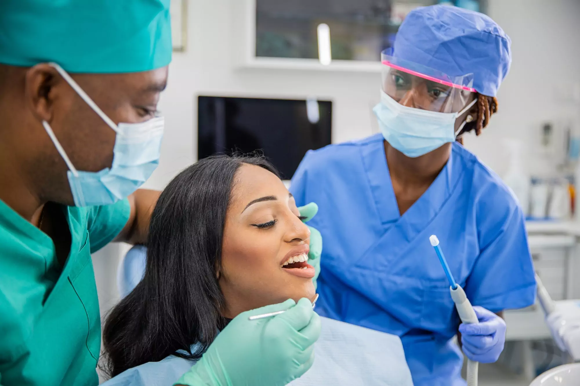 Girl with open mouth during a dental visit, dentist and assistant at work, dental health concept