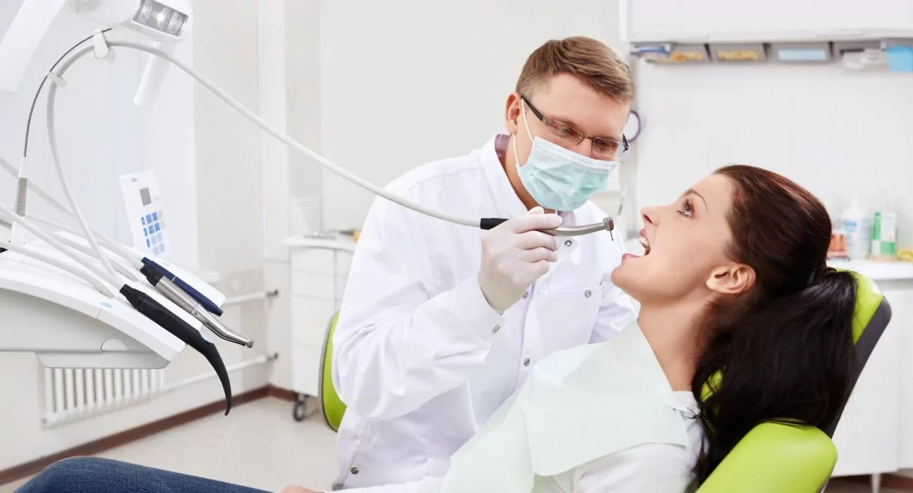 The dentist treats teeth of patient